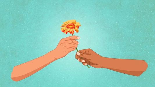 One hand gently giving a flower to another hand, symbolizing kindness, compassion, and small acts of care