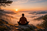 A person meditating on a mountaintop at sunrise, surrounded by misty mountains and nature, with warm soft light creating a peaceful and calm atmosphere.